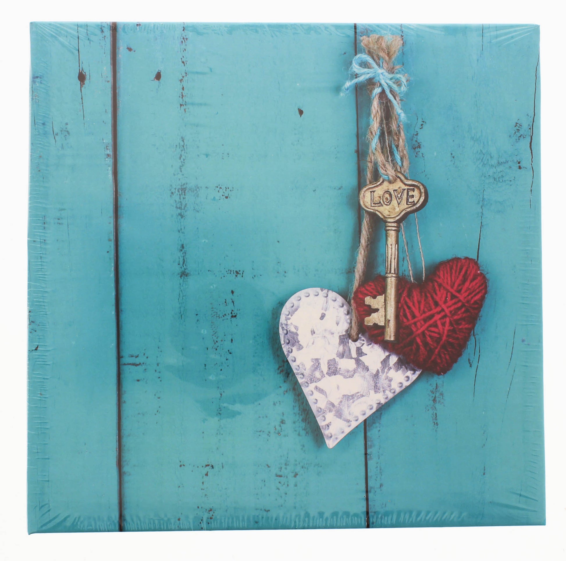 A wooden heart and key are displayed on a blue background, representing cherished moments on a Hama photo album.