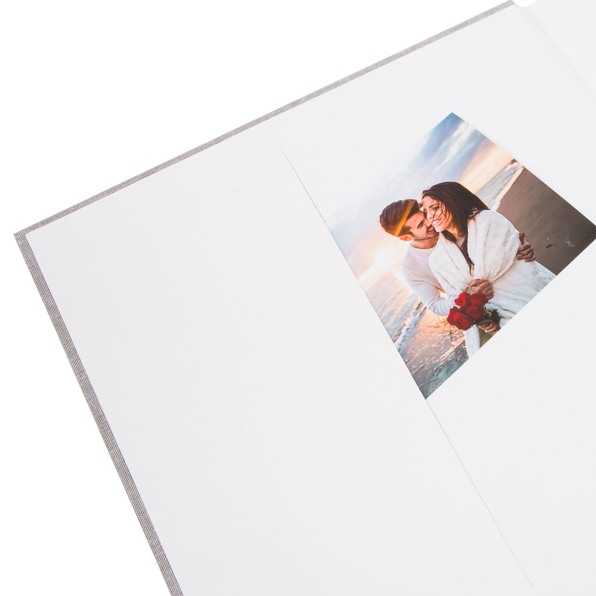 A grey Goldbuch photo album with three photographs showcased on its surface.