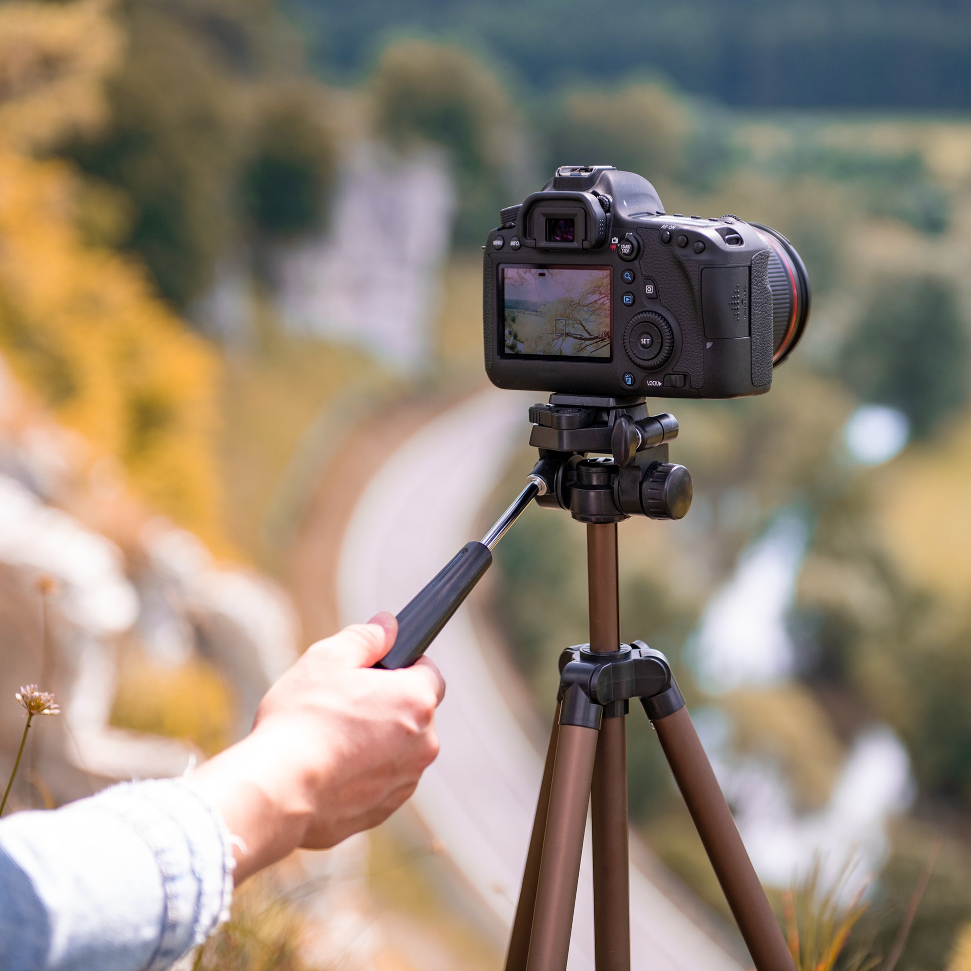 A Hama tripod supporting a camera, positioned for photography, showcasing stability and professional equipment.