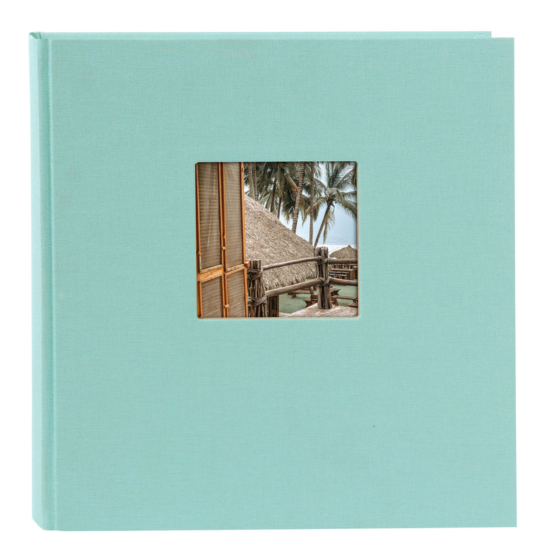 A Goldbuch aqua blue photo album with a cover illustration of a beach house, showcasing its hardcover design and black pages.