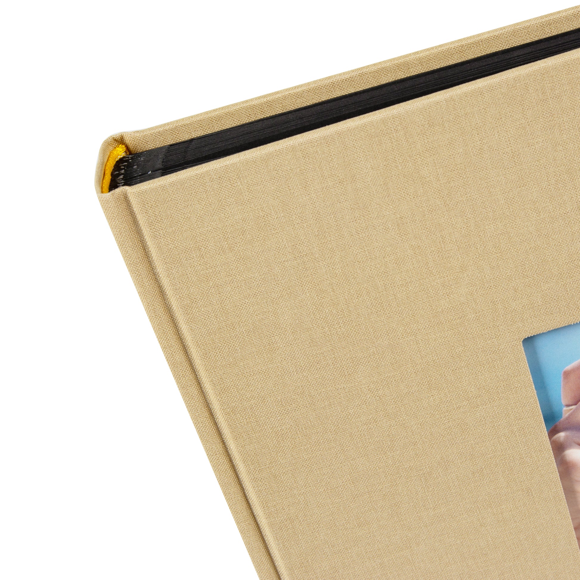 A Goldbuch beige photo album with a cover illustration of a girl taking photos showcasing its hardcover design and black pages.