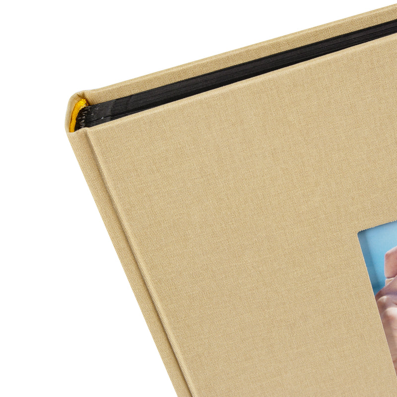 A Goldbuch beige photo album with a cover illustration of a girl taking photos showcasing its hardcover design and black pages.