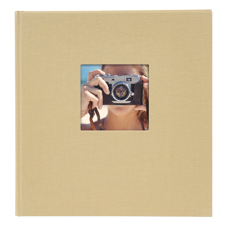 A Goldbuch beige photo album with a cover illustration of a girl taking photos showcasing its hardcover design and black pages.