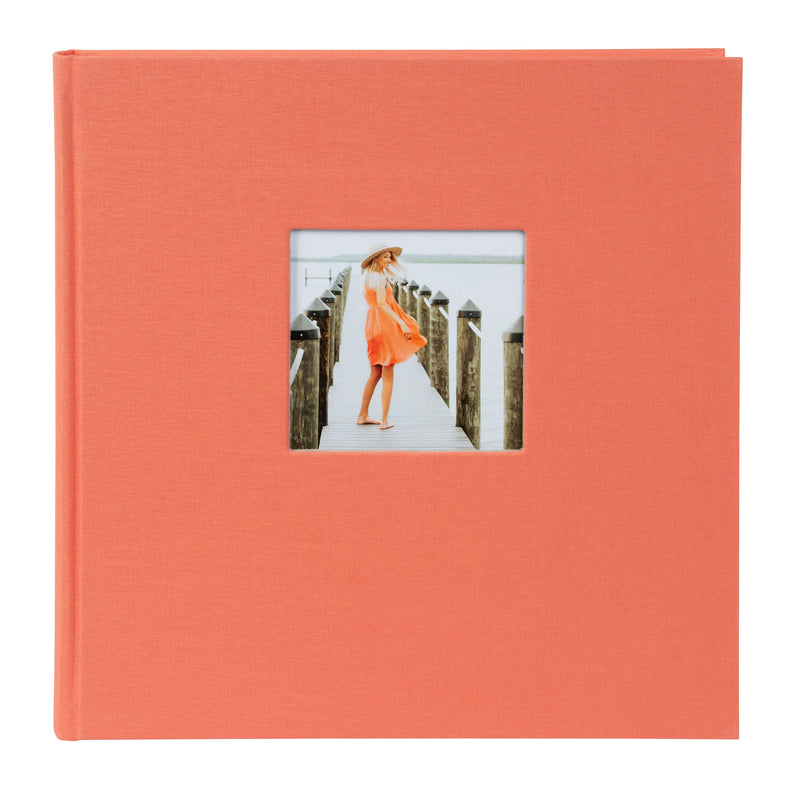  A salmon color Goldbuch hardcover photo album featuring an image of a woman walking on a pier.
