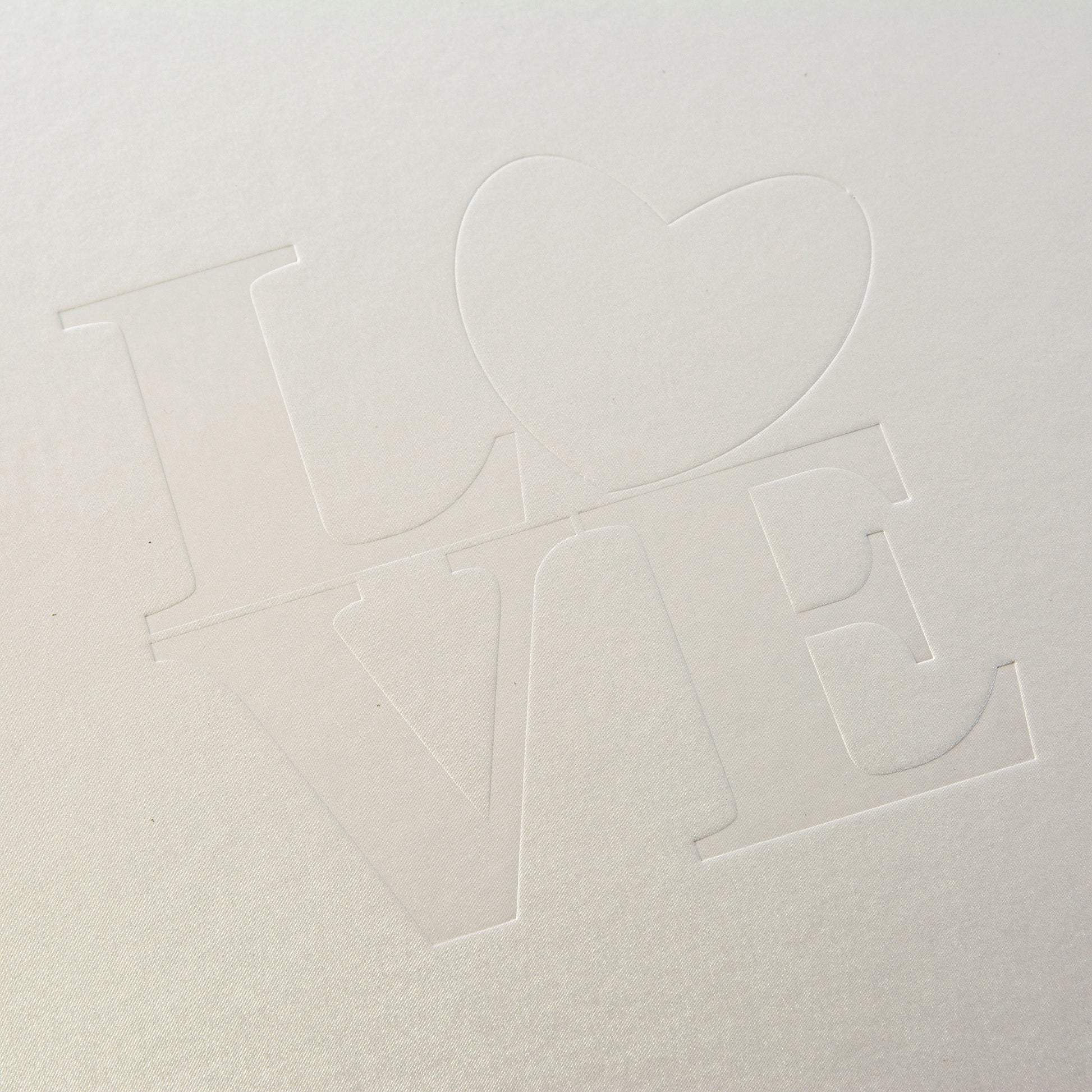 A white Goldbuch wedding photo album showcasing the word "love" beautifully positioned in the middle of the cover.
