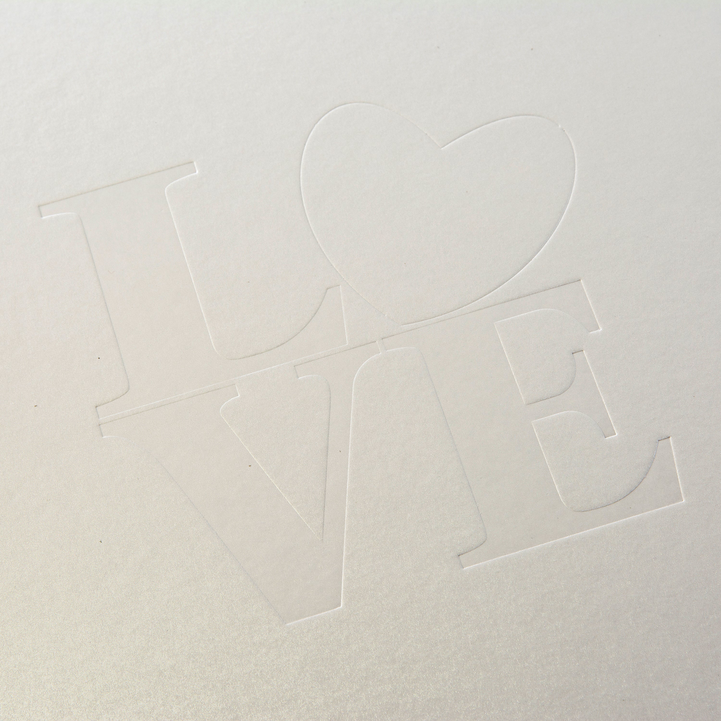A white Goldbuch wedding photo album showcasing the word "love" beautifully positioned in the middle of the cover.
