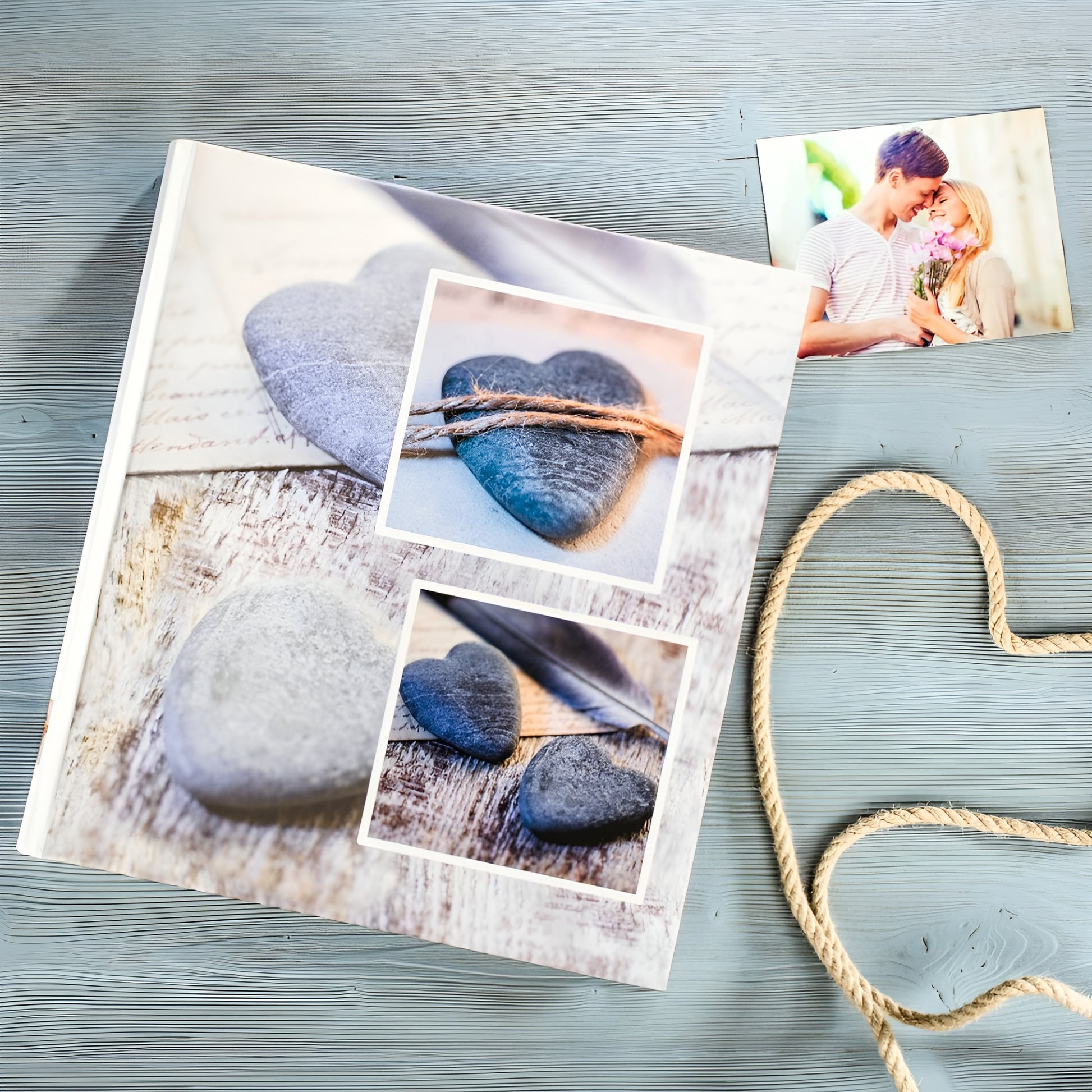 A Hama photo album accompanied by a heart-shaped stone and a rope, representing love and treasured moments.