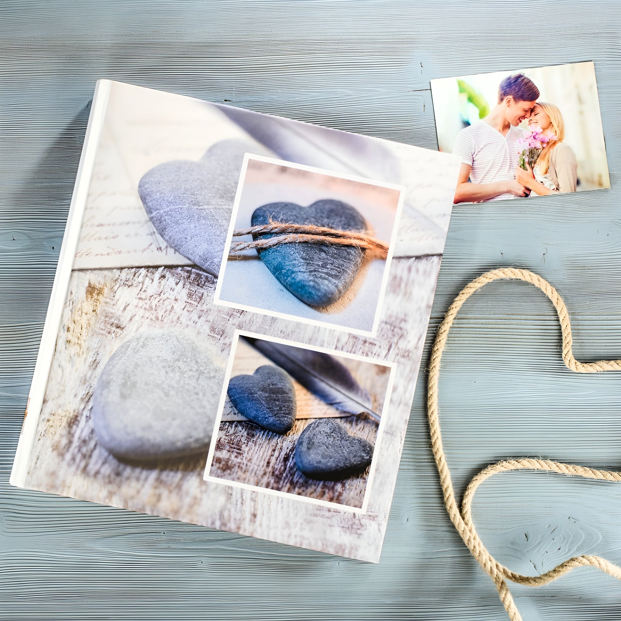 A Hama photo album accompanied by a heart-shaped stone and a rope, representing love and treasured moments.