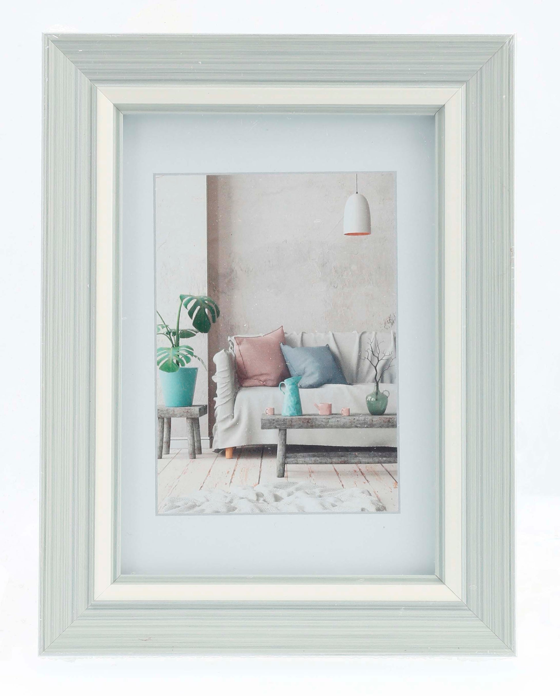 A Hama photo frame in white showcasing a picture of a comfortable couch, perfect for home styling.