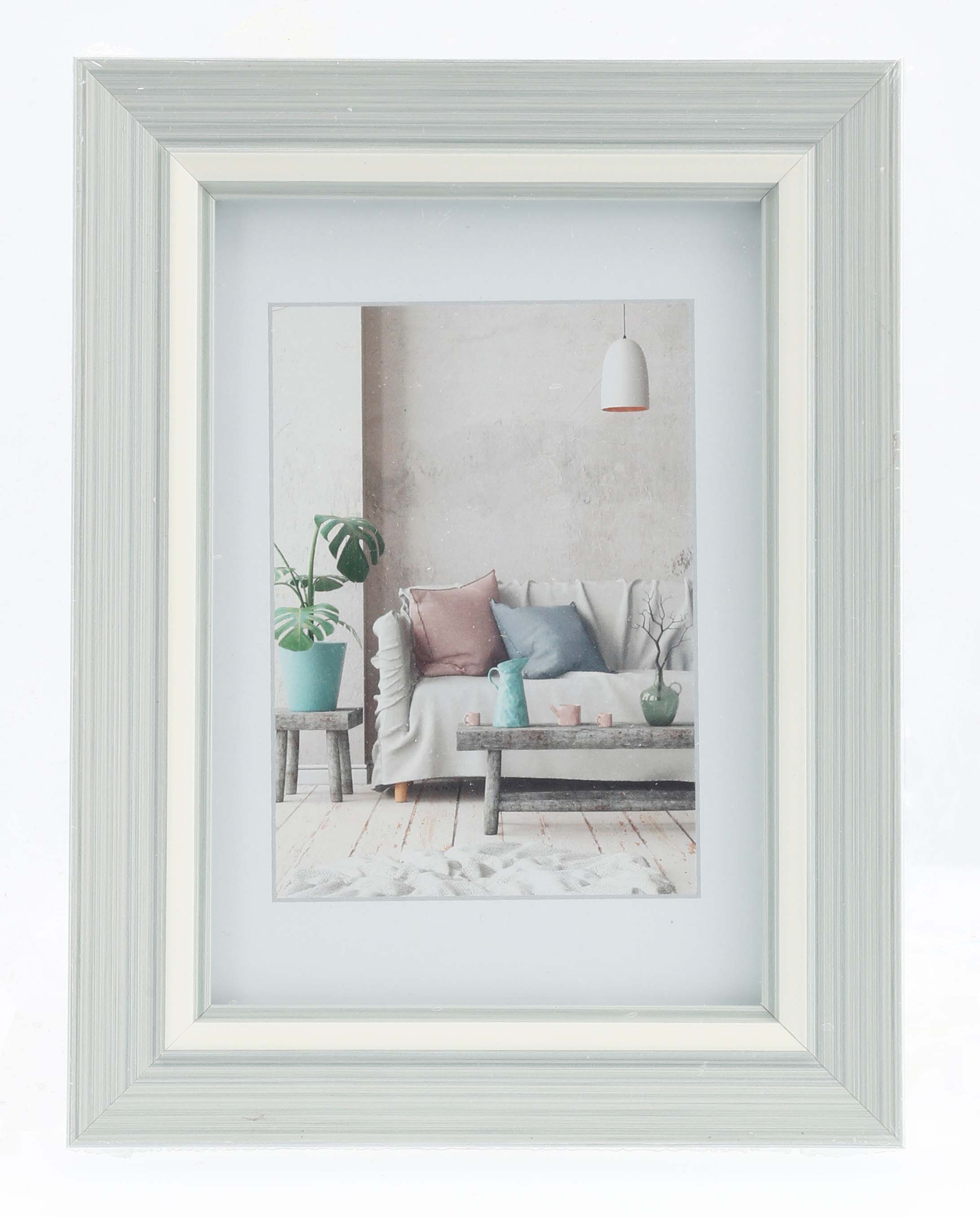 A Hama photo frame in white showcasing a picture of a comfortable couch, perfect for home styling.