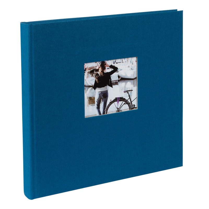 A Goldbuch blue photo album with a cover illustration of a woman cycling, showcasing its hardcover design and black pages.