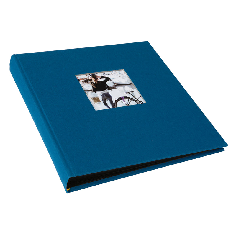 A Goldbuch blue photo album with a cover illustration of a woman cycling, showcasing its hardcover design and black pages.