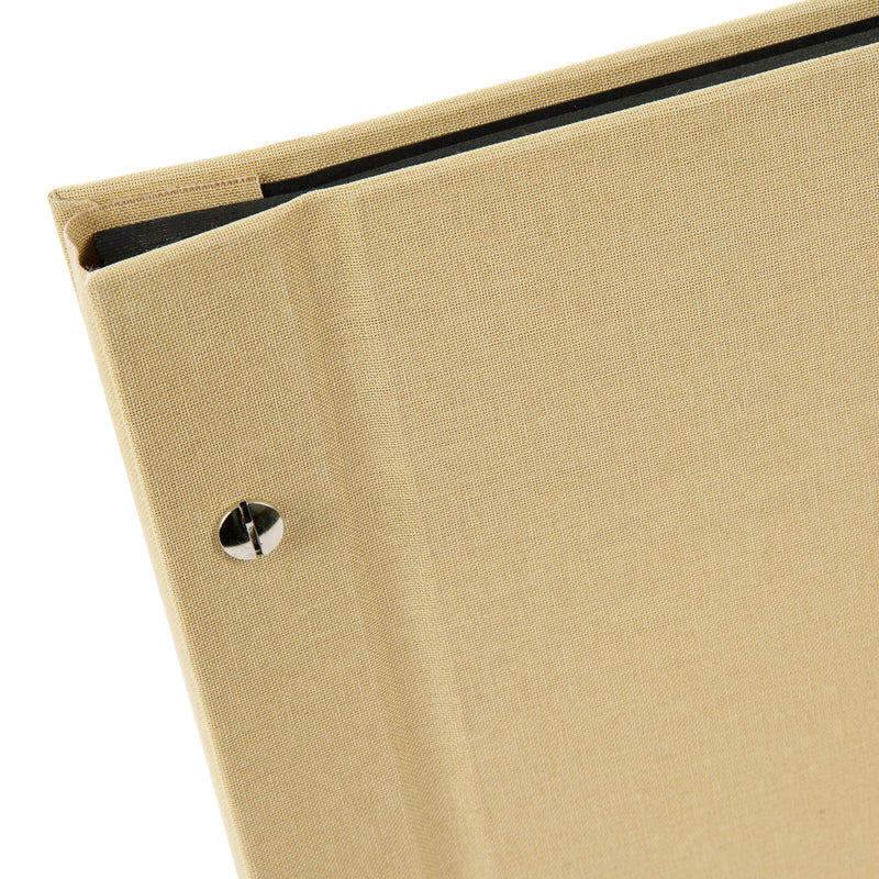 A Goldbuch beige photo album with a cover illustration of a woman taking photos, showcasing its hardcover design and black pages.