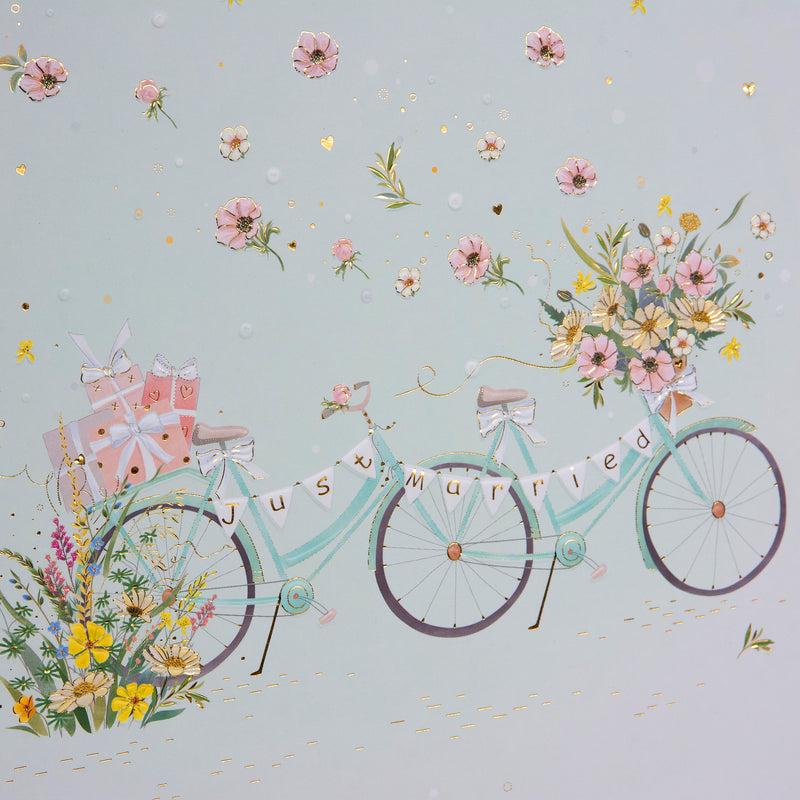A white Goldbuch photo album adorned with a picture of two bicycles alongside vibrant flowers.
