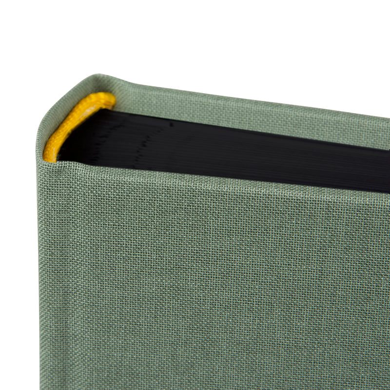 A Goldbuch artichoke green photo album with a cover illustration of a van with a tent on the roof, showcasing its hardcover design and black pages.