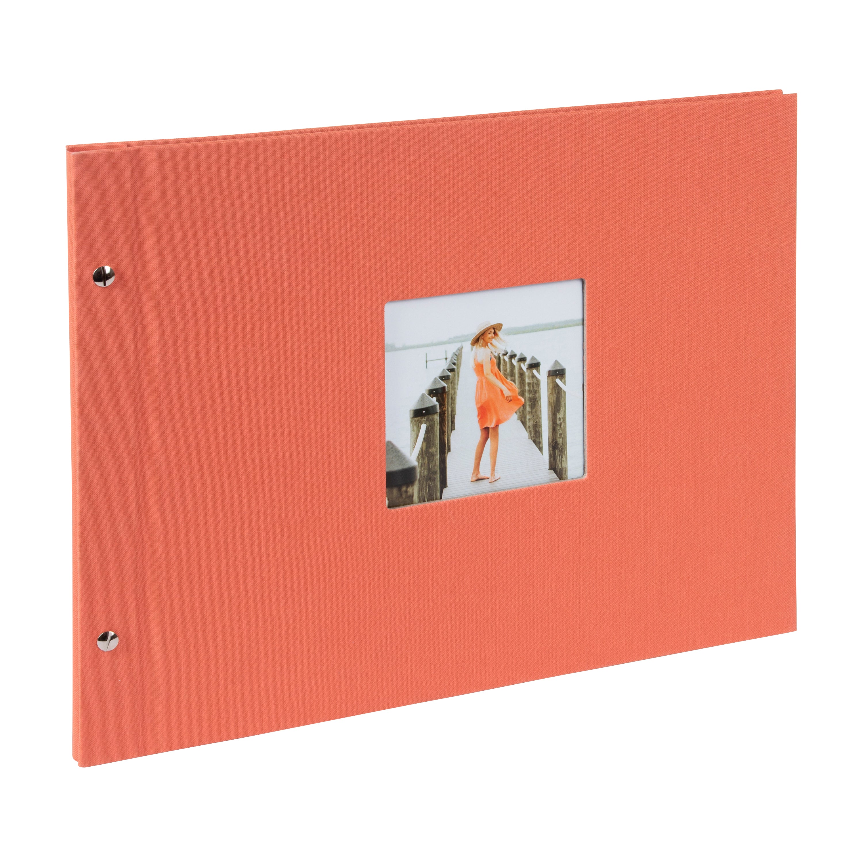 A coral Goldbuch photo album with a woman walking on a deck, showcasing a serene waterfront scene.
