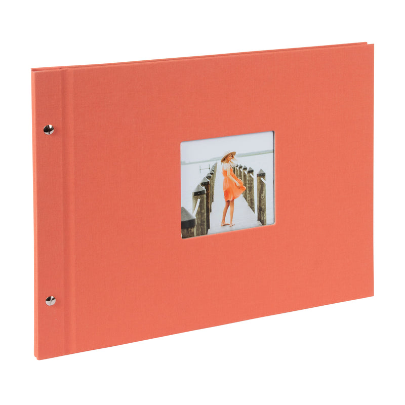 A coral Goldbuch photo album with a woman walking on a deck, showcasing a serene waterfront scene.
