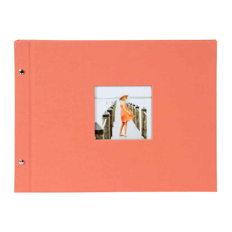 A coral Goldbuch photo album with a woman walking on a deck, showcasing a serene waterfront scene.
