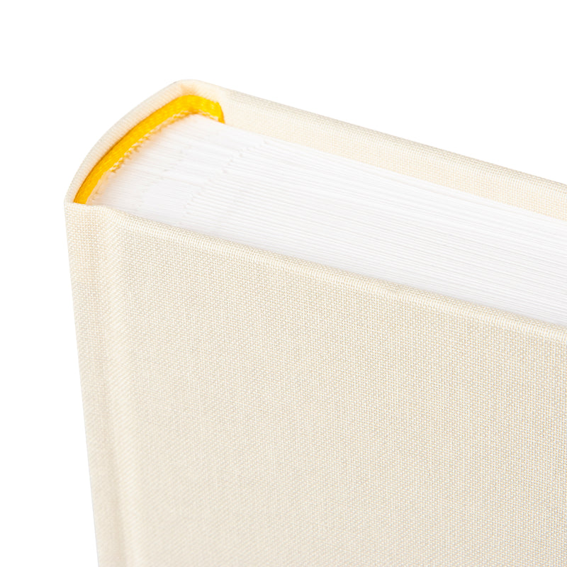 A Goldbuch photo album with three photographs showcased on its surface.