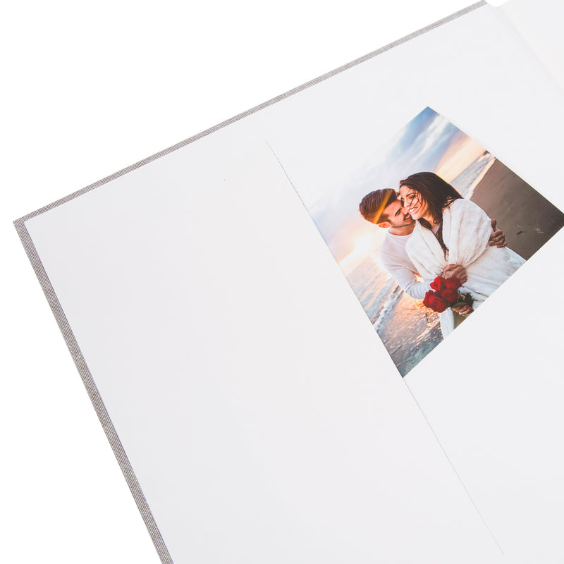 A grey Goldbuch photo album with three photographs showcased on its surface.