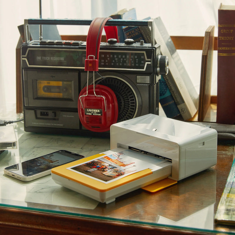 A woman displays a photo just printed from a Kodak instant printer, highlighting the joy of instant photography.