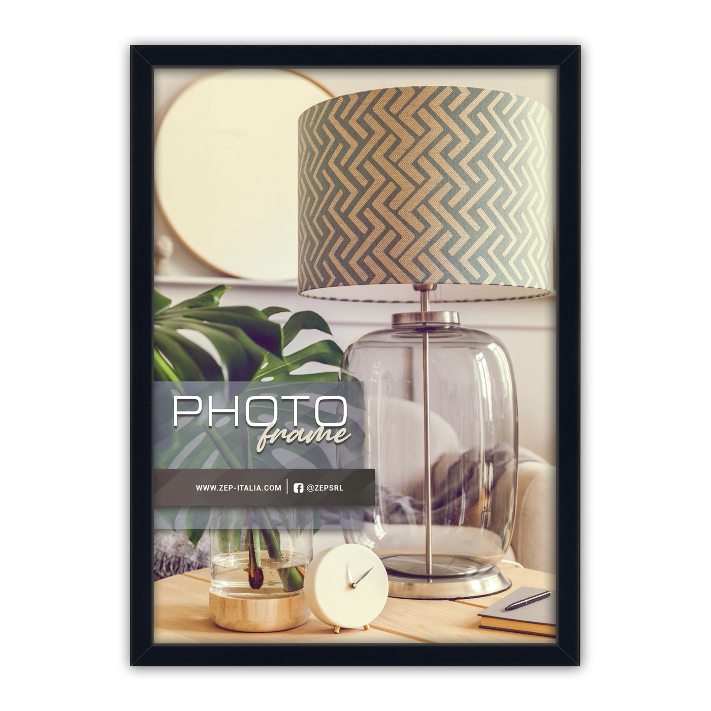 A black-framed ZEP photo frame displayed on a white background, showcasing a placeholder photo of a modern table lamp with a beige and gray geometric patterned shade, a glass base, and a small round clock.